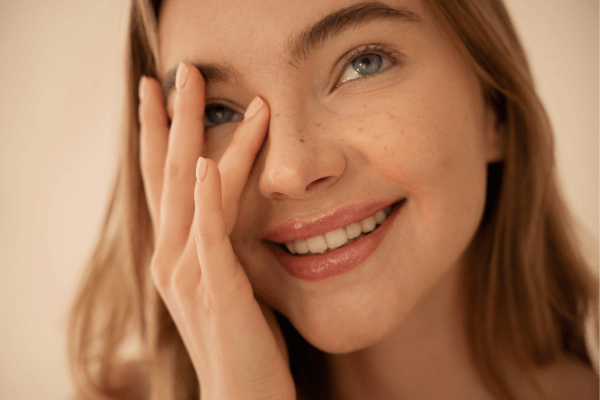 Une jeune femme se touche le visage