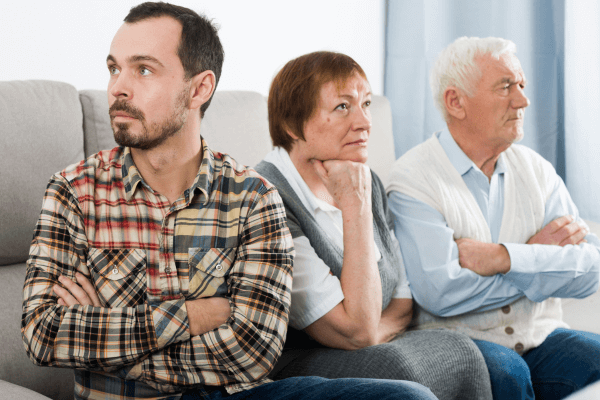 Un homme fait la tête à ses parents
