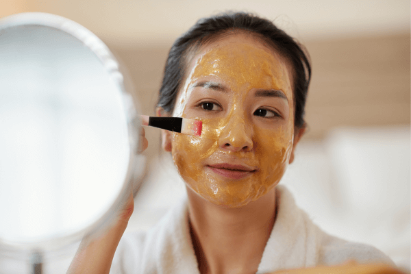 Une femme s'applique un masque fait maison au pinceau