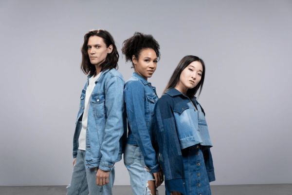 Un homme et deux femmes portent des vestes en jean