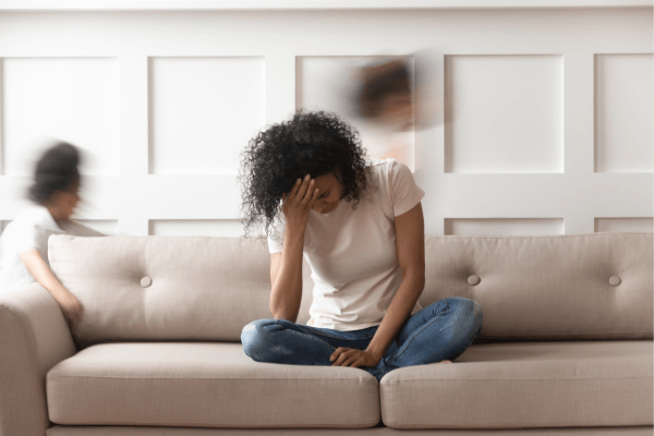 Une femme assise sur le canapé, épuisée