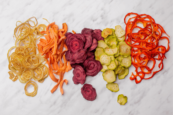 Des petits tas de l'aliments déshydratés (citron, carotte, betterave, courgette et poivron)