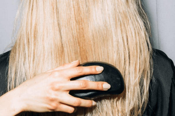 Une femme brosse ses longs cheveux blonds