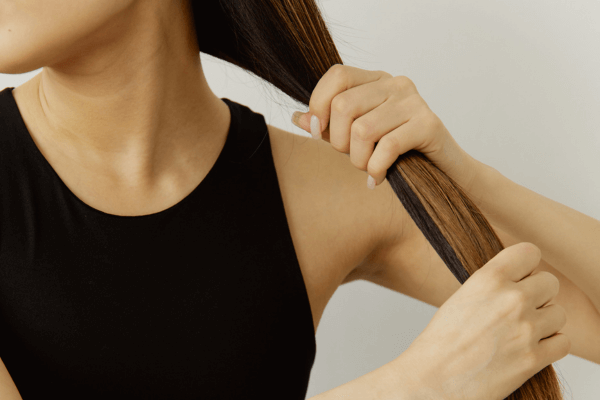Une femme tenant ses longs cheveux dans les mains