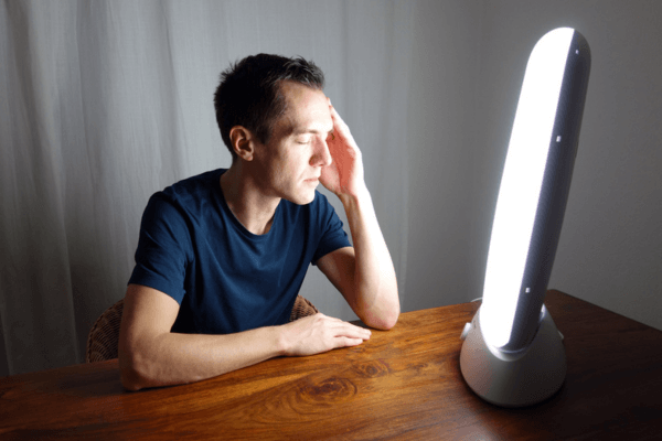 Un homme utilise une lampe de luminothérapie